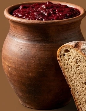 Gliniany garnek z zakwasem buraczanym i kromka żytniego chleba. Grafika wygenerowana przez AI.